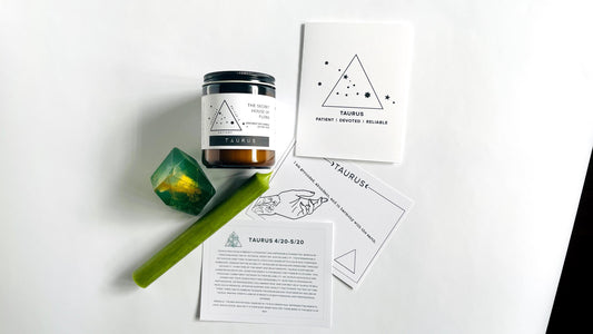 Zodiac candle with taper candle, gem shaped soap with affirmation cards, and zodiac birthday card on a white surface