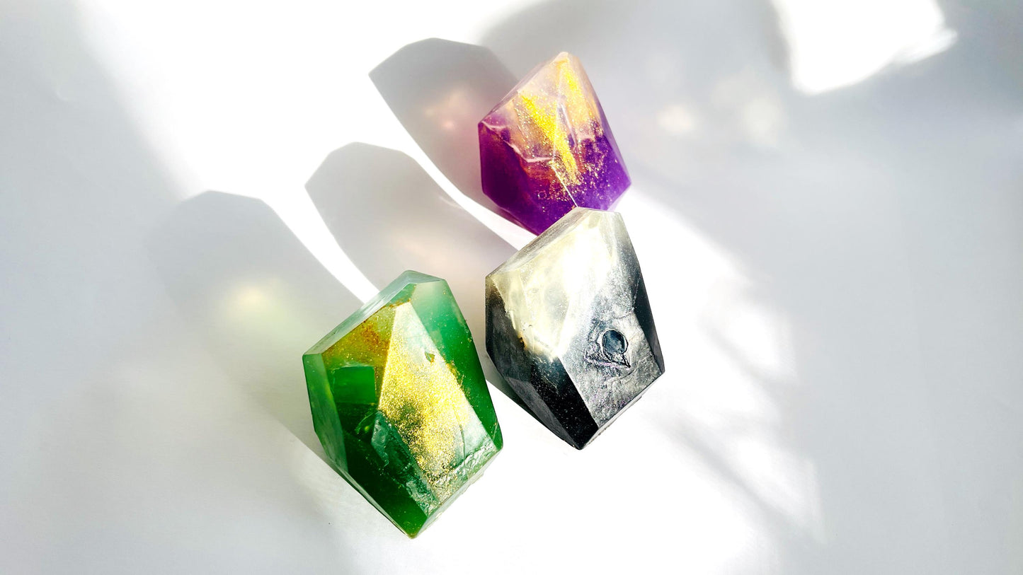 Three colorful crystal-like gem shaped soaps on a white background
