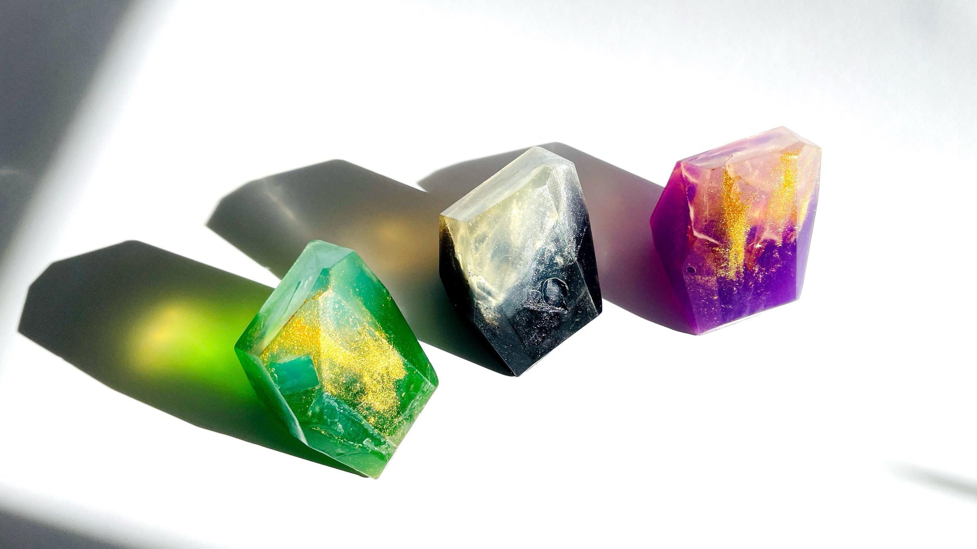 Colorful crystal-like gem shaped soaps  on a reflective surface