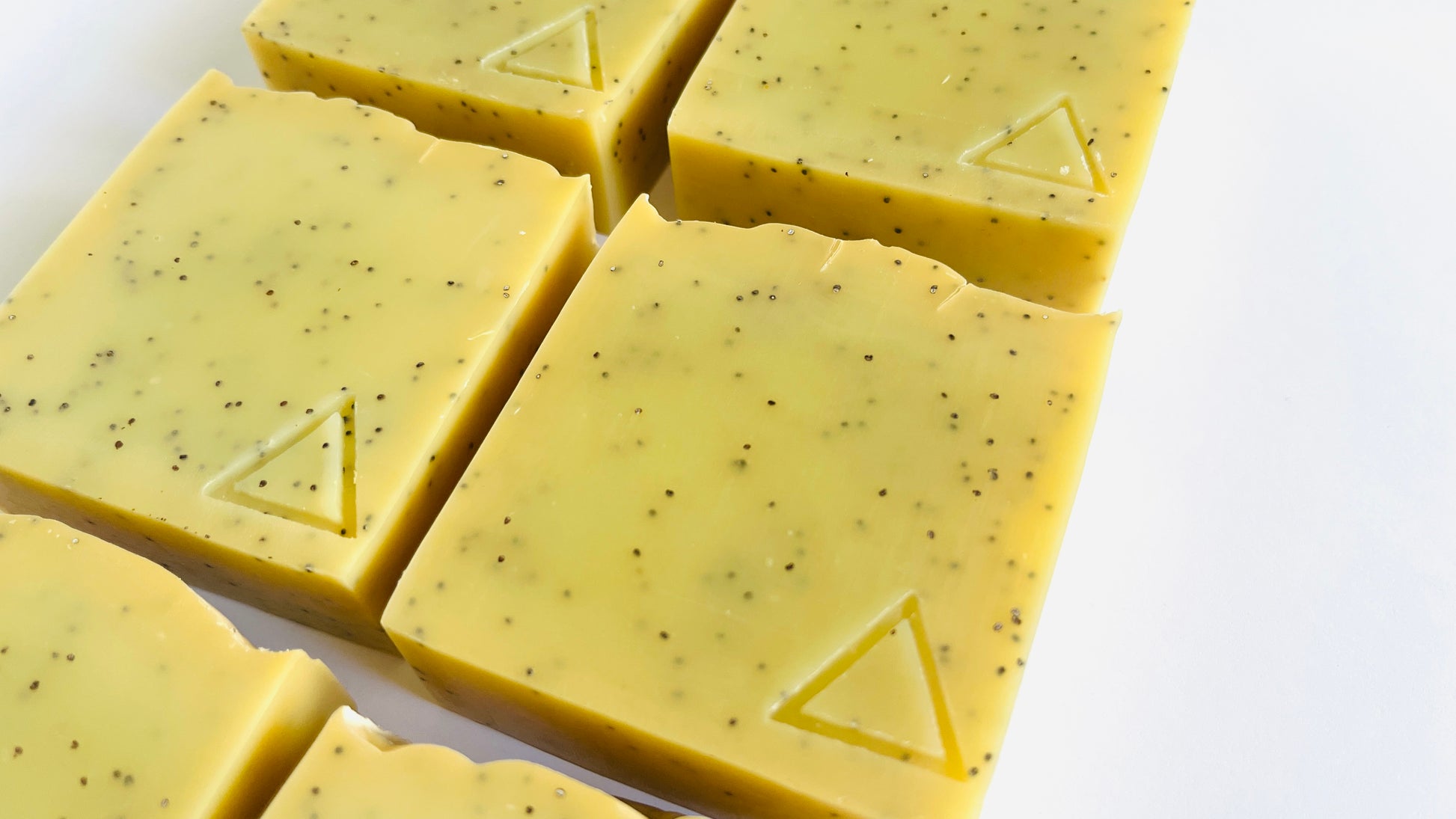 6 Yellow soap bars with triangle patterns on a white background