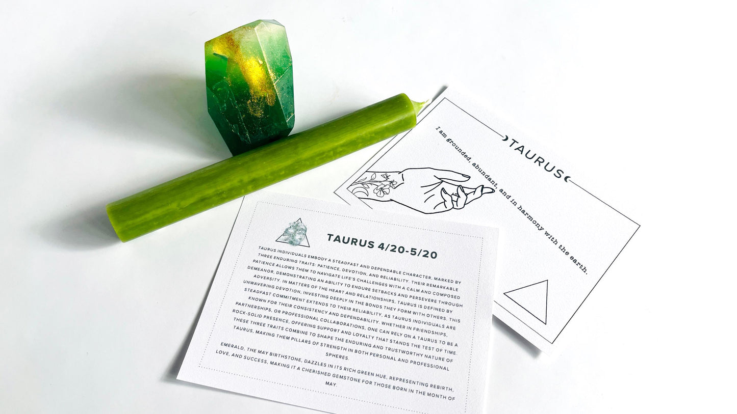 Green gem shaped soap, taper candle, and astrological cards on a white surface.