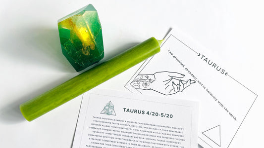 Green taper candle and  gem shaped soap with Taurus zodiac cards on a white background