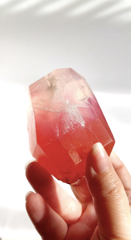 Hand holding a pink gem shaped soap with silver sparkle against a white background.