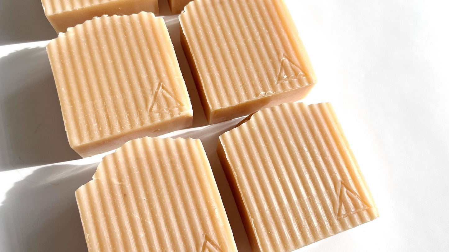 5 Square pink soap bars with soft ridges on a white background.